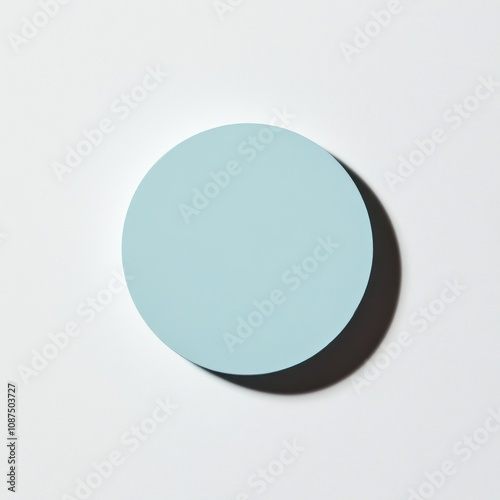 A simple light blue circular shape casting a shadow against a white background.