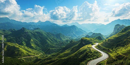 Scenic mountain landscape featuring a winding road on a mountain plateau, showcasing lush green mountains under a bright blue sky in this stunning visual of nature s beauty.
