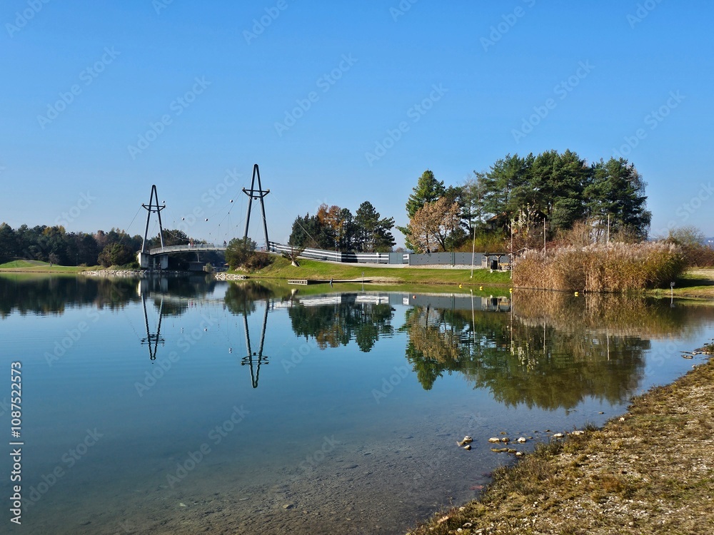 Wunderschöne Spiegelung von Böschung, Bäumen und Rasen in See im Herbst