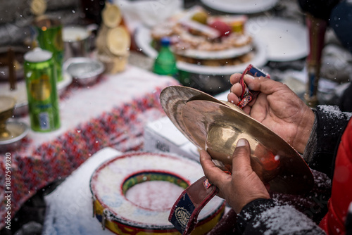 Puja ritual. Lama's hands holding cymbals while reciting prayers. In Everest base camp, Nepal. photo