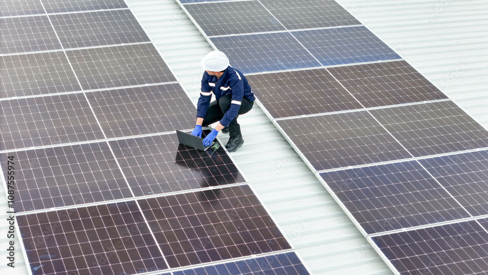 Aerial view of a rooftop with solar panels, showing a technician in safety gear performing maintenance. The scene highlights renewable energy, solar technology, and sustainable infrastructure. Aerial view of a rooftop with solar panels, showing a technician in safety gear performing maintenance. The scene highlights renewable energy, solar technology, and sustainable infrastructure.