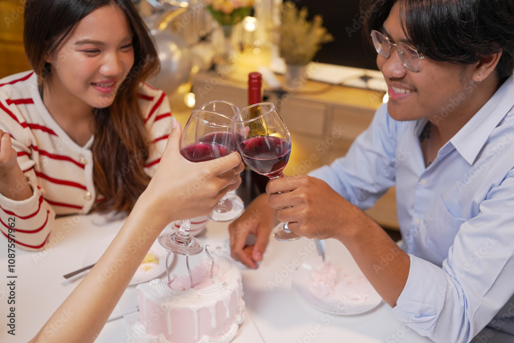 Happy friends with tasty cake and glasses of sparkling wine celebrating birthday indoors