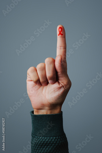 red awreness ribbon painted in his finger photo