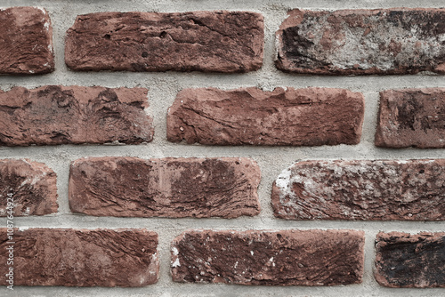 Close up of aged brick wall with mortar joints and texture. Weathered brick wall texture with effects of time and elements, textured construction backdrop