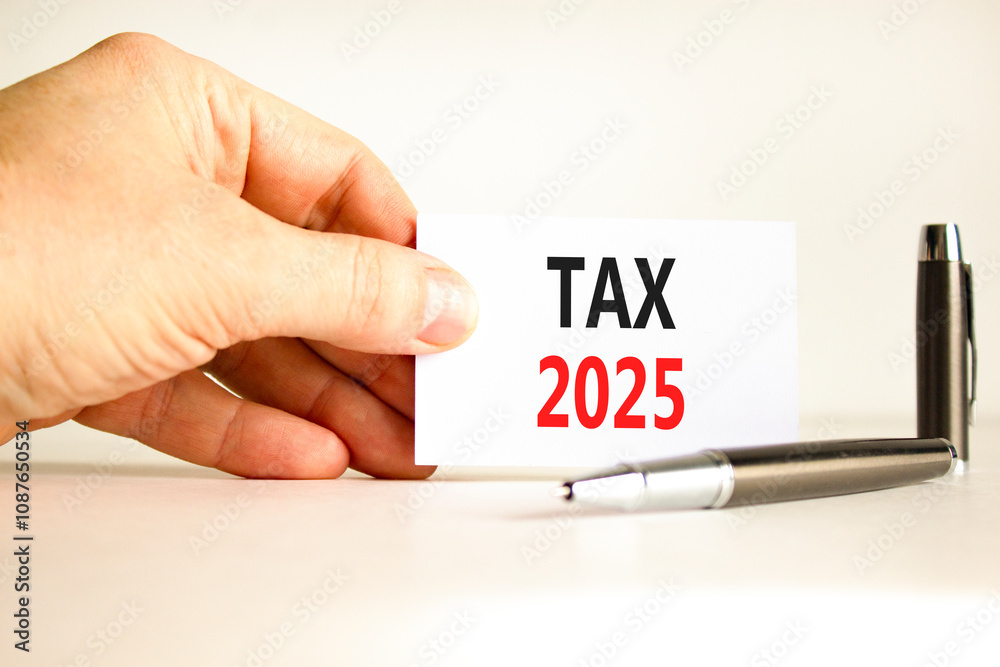 Planning tax 2025 new year symbol. Concept words Tax 2025 on beautiful white card. Beautiful white background. Businessman hand. Business tax 2025 new year concept. Copy space. Planning tax 2025 new year symbol. Concept words Tax 2025 on beautiful white card. Beautiful white background. Businessman hand. Business tax 2025 new year concept. Copy space.