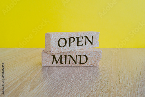Concept word open mind on brick blocks. Beautiful wooden table, yellow background. Business open mind concept