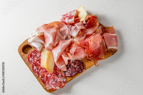 Wooden cutting board with tasty appetizers of cold cuts, ham, salami , mortadella and cheese on a white background photo