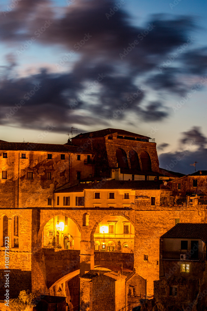 Fototapeta premium Sovana, Tuscany, Italy, long exposure blue hour night photograph, travel destination, amazing cityscape, walk in the city
