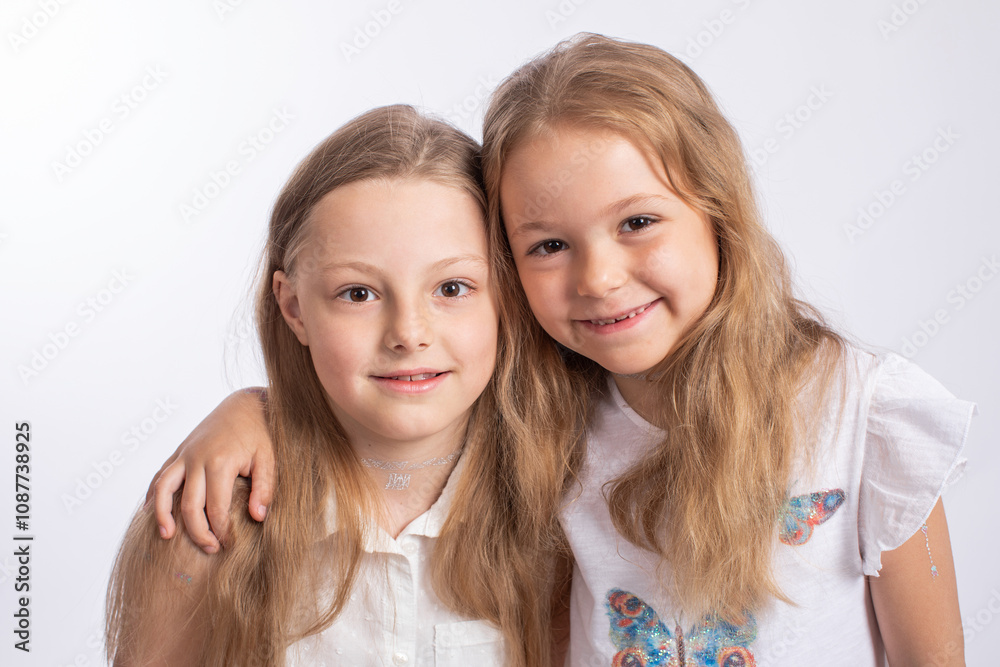 Close up two beautiful girls sisters, isoated on white background Close up two beautiful girls sisters, isoated on white background