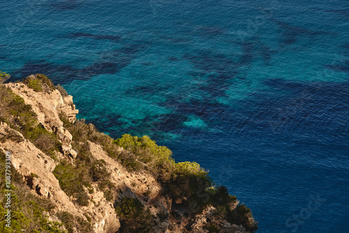 El mar turquesa del mediterráneo en Formentera, Islas Baleares, España, con pequeño barco en el mar azul 