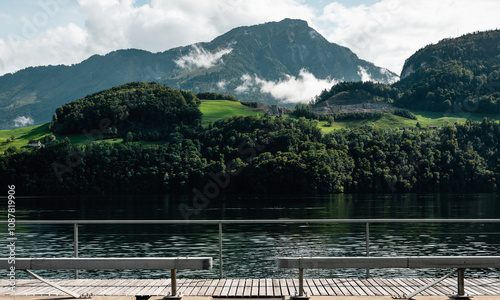 Alpnachersee mountain lake - view from the boardwalk along the northern bank. Clouds covering Stanserhorn alpine peak behind the waters of Alpnacherse. photo