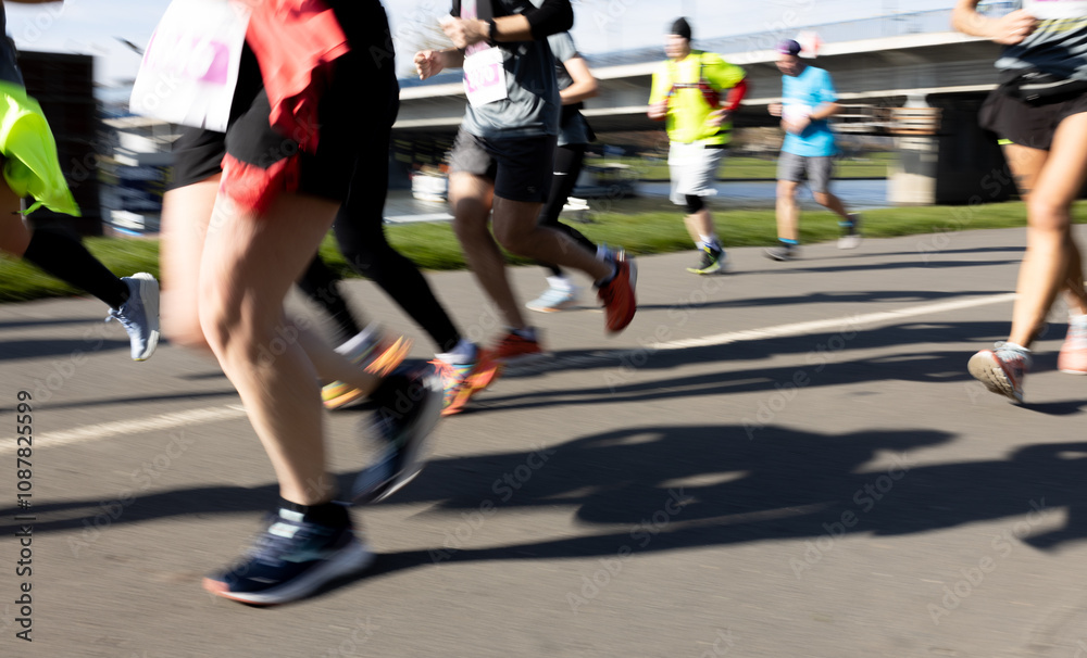 Motion blurred marathon runners in a city. Group of marathon runners compete in the race outdoors