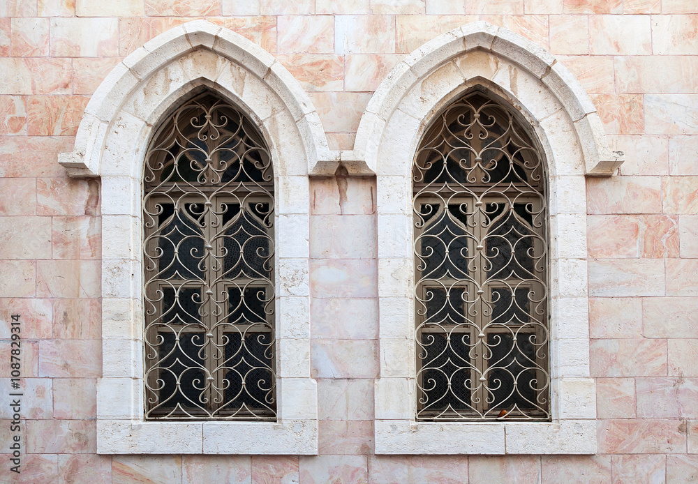 Intricate gothic windows design on historic stone building facade Intricate gothic windows design on historic stone building facade