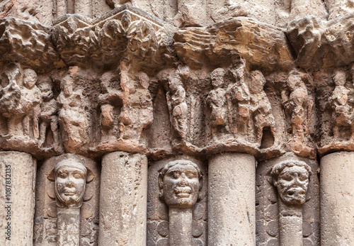 Intricate carvings depicting historical figures on columns in Obanos, Spain during the evening light photo