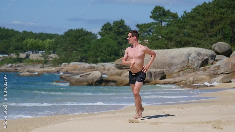 Man running along a beach on a sunny day with clear skies