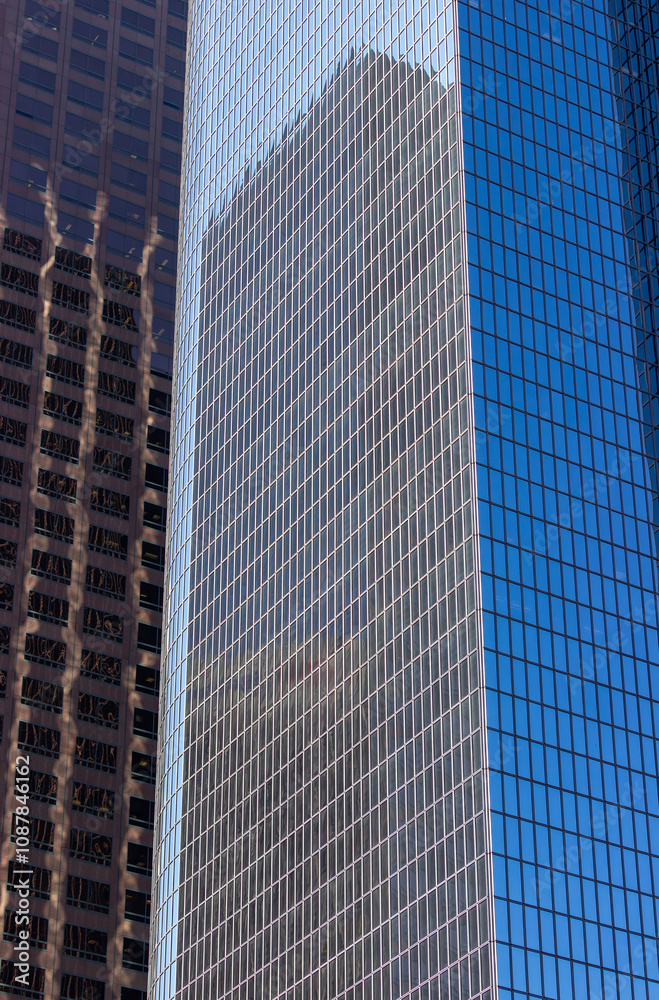 A close-up view of modern office buildings in downtown Los Angeles. The buildings feature sleek glass facades that reflect the surrounding structures, creating an intricate pattern of reflections. A close-up view of modern office buildings in downtown Los Angeles. The buildings feature sleek glass facades that reflect the surrounding structures, creating an intricate pattern of reflections.