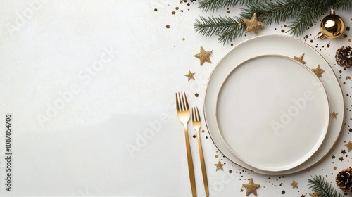 Elegant holiday table setting with white plate and golden utensils on a festi...