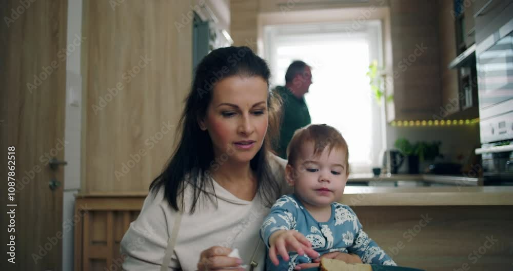 Mother feeding baby at dining table with nurturing care, baby exploring food while sharing a warm and joyful moment in a cozy family home Mother feeding baby at dining table with nurturing care, baby exploring food while sharing a warm and joyful moment in a cozy family home