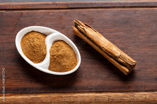 cinnamon chips and powder on rustic wood photo