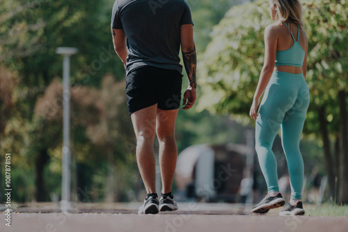 Two friends enjoy a relaxing walk in a sunny park, embracing fitness and well-being. The lush green surroundings provide a perfect backdrop for outdoor exercise and leisure activities.