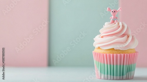 Colorful cupcake with pink frosting and decorative figure on a pastel background