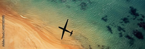 Airplane flying over a serene beach during daylight with clear turquoise wate...