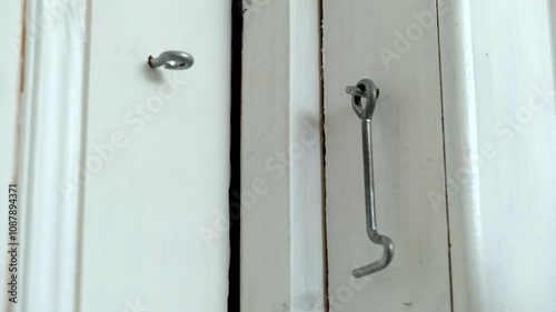 A person is currently opening a door with a hook in their hand