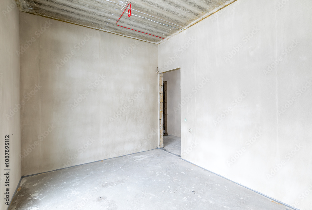 Fototapeta premium The room is under construction with a rough finish, plastered walls, concrete floor. Living Room Bedroom Area