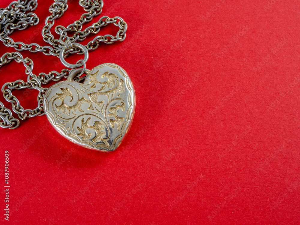 Fototapeta premium Engraved metal heart on a red background. Valentine's Day.