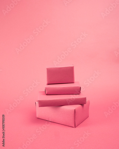 collection of roughly wrapped boxes in various sizes on pink background photo