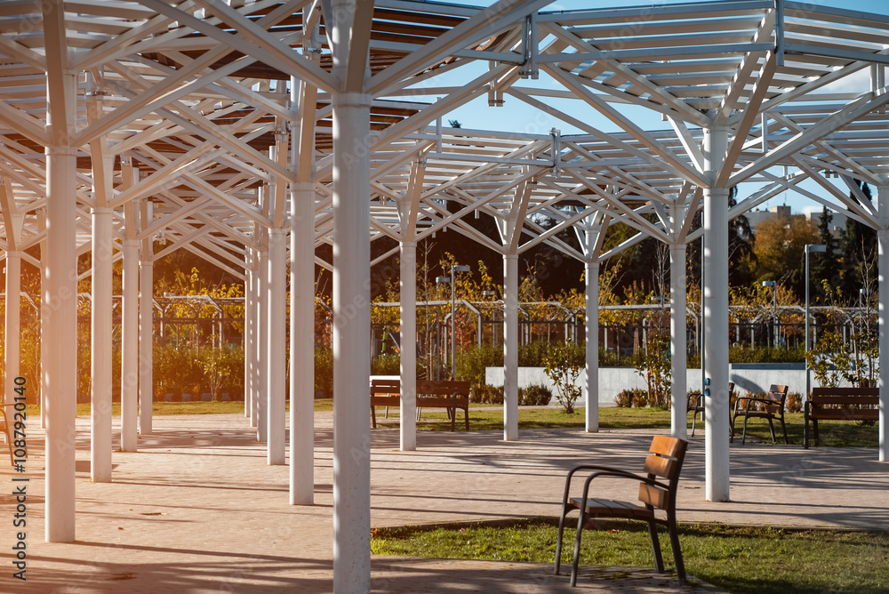 modern architectural design showcasing white metal structures supporting public gathering space in urban park during daylight modern architectural design showcasing white metal structures supporting public gathering space in urban park during daylight