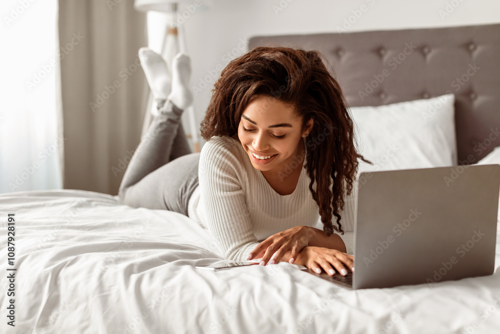 Two Factor Authentication. Portrait of positive black female using phone and laptop in bed, reading message with security code to access financial data online, free space Two Factor Authentication. Portrait of positive black female using phone and laptop in bed, reading message with security code to access financial data online, free space