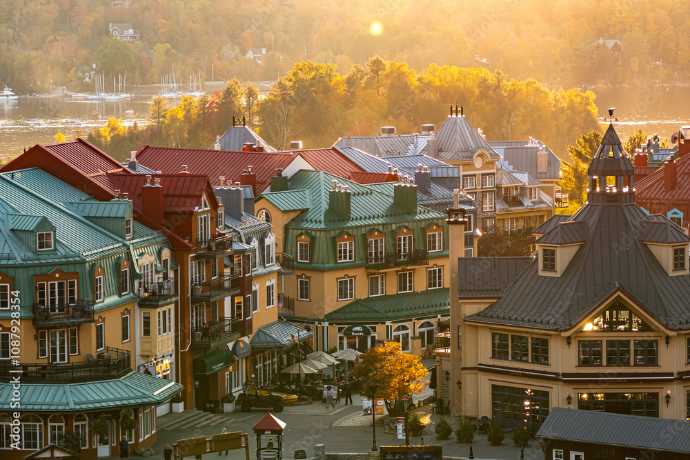 Fototapeta premium Mont-Tremblant, Quebec, Canada - October 03, 2023: House roofs surrounded by autumnal maple trees