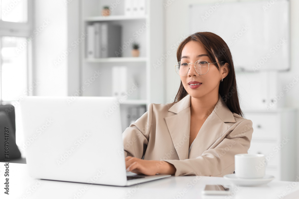 Asian businesswoman working with laptop at table in office Asian businesswoman working with laptop at table in office
