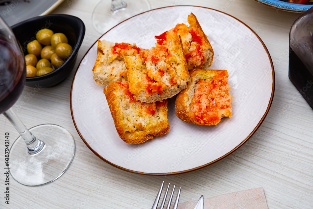 Pa amb tomaquet, traditional Spanish snack, toasted bread with tomato rubbed over and seasoned with olive oil and salt Pa amb tomaquet, traditional Spanish snack, toasted bread with tomato rubbed over and seasoned with olive oil and salt