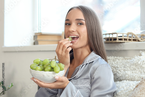 Young woman in pajamas eati...