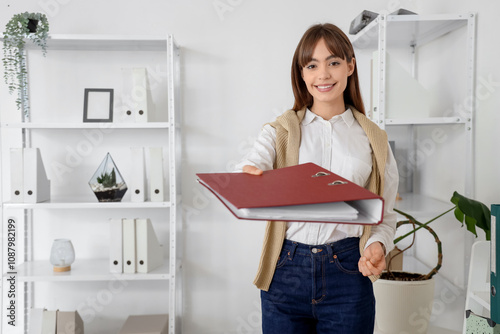 Young businesswoman with folder in office