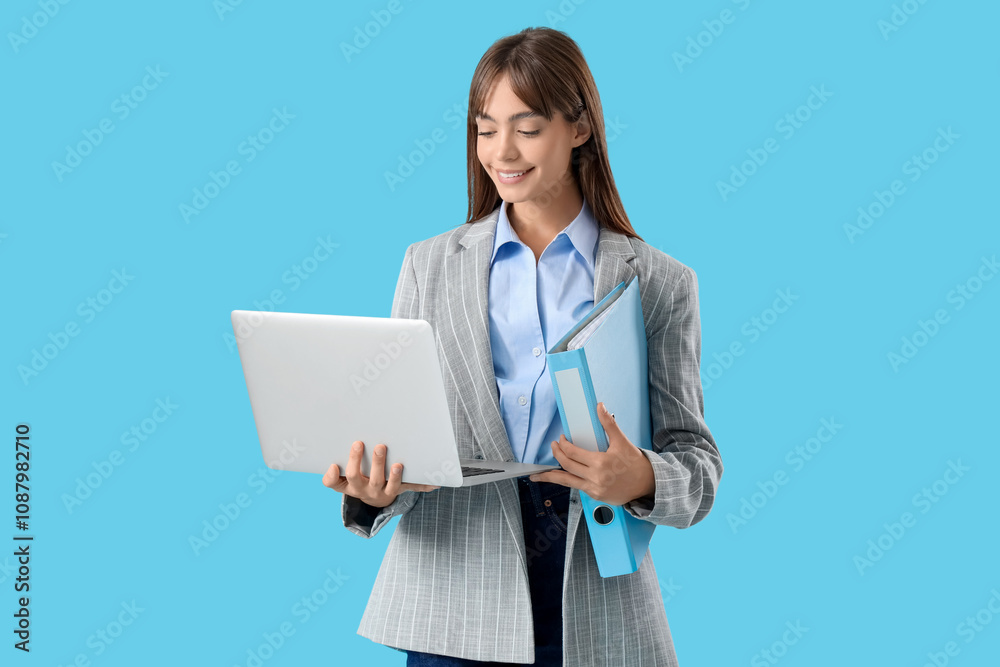 Young businesswoman with folder and laptop on blue background Young businesswoman with folder and laptop on blue background