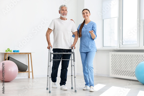 Nurse helping senior man with walking frame in clinic