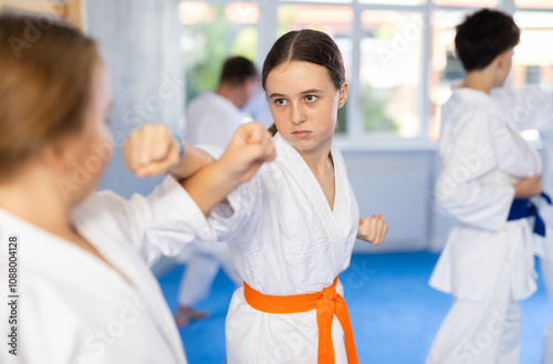 Two girls learn to throw punches and kicks in sparring for karate training photo