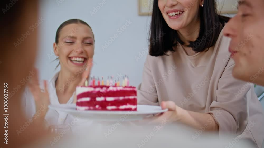 Friends bringing birthday cake at home party closeup. Excited guy blowing candle Friends bringing birthday cake at home party closeup. Excited guy blowing candle