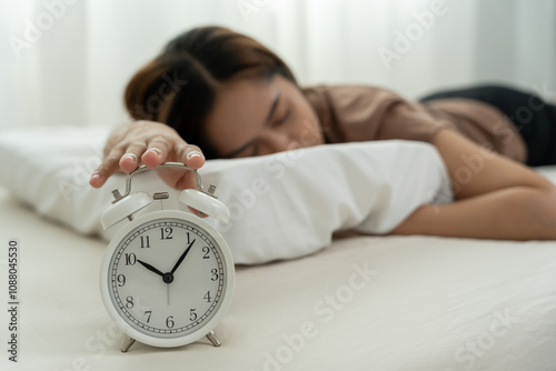 Lazy Asia young woman close a clock alarm, lady is late appointment or work or class study, overslept, difficulty get up in mornings, time worried, not on time, sleepy, over due, Hurry up time