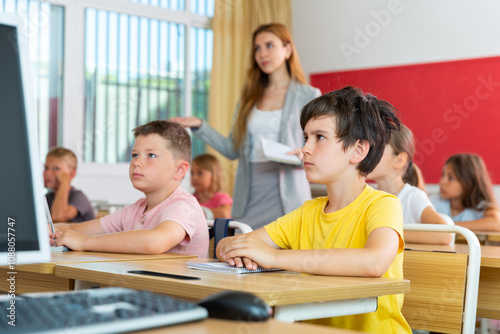 Portrait of diligent schoolboy who writing exercises at lesson in primary school