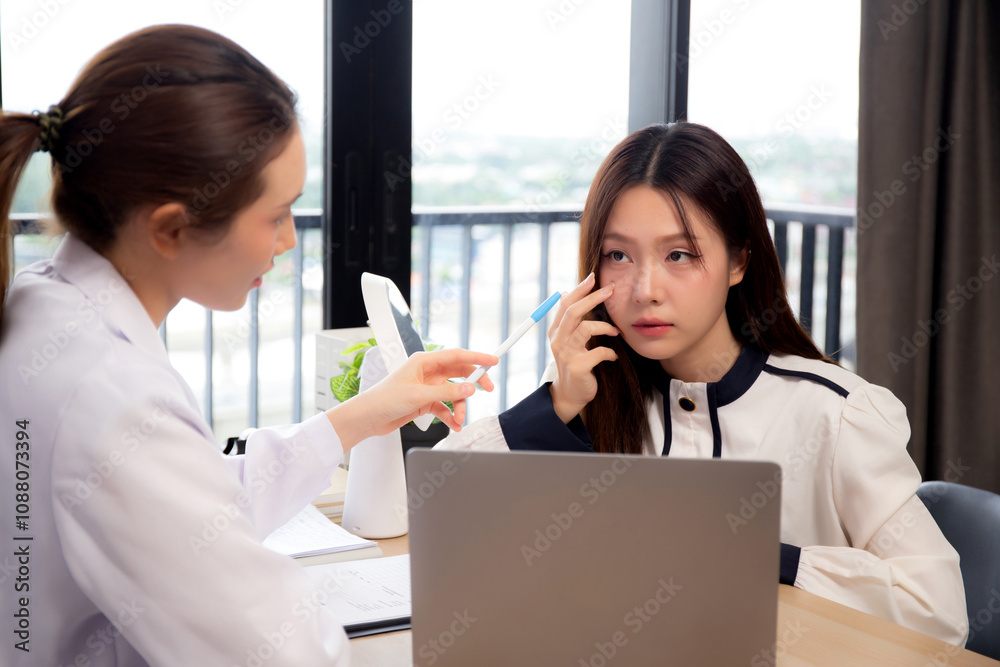 Young asian patient woman consulting with doctor in coat about wrinkle and skin for rejuvenate and beauty while watching laptop in modern medical office, doctor explaining and diagnostic facial. Young asian patient woman consulting with doctor in coat about wrinkle and skin for rejuvenate and beauty while watching laptop in modern medical office, doctor explaining and diagnostic facial.