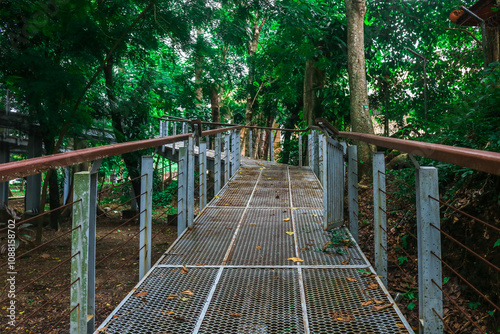 Design of an iron bridge around the Wisdom Park at Gadjah Mada University with views of the lake and large trees photo