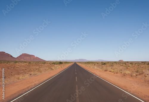 Open road stretching through a vast desert landscape under a clear blue sky, representing freedom, adventure, and the journey ahead. Ideal for travel, exploration, or road trip-themed projects.