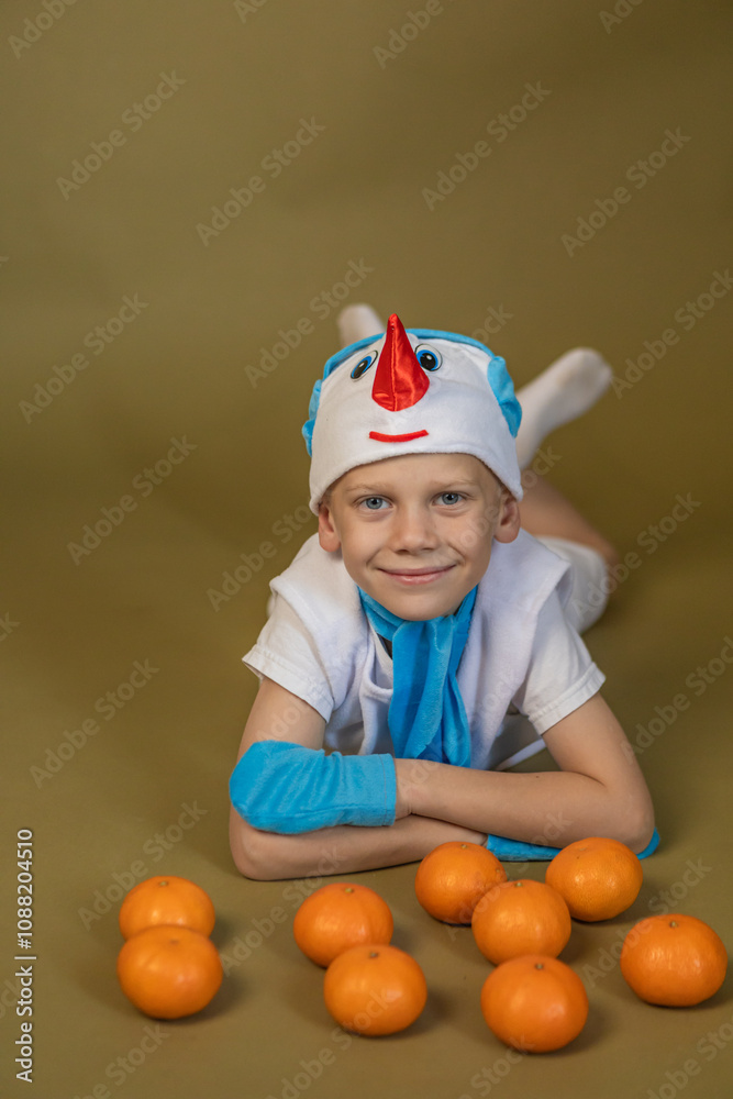 boy in a snowman costume lies with tangerines boy in a snowman costume lies with tangerines
