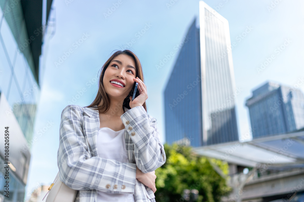 Asian Businesswoman Using Phone In Front of Cityscape Background Asian Businesswoman Using Phone In Front of Cityscape Background