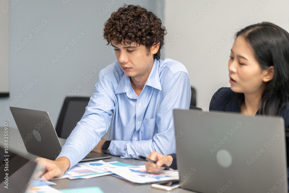 Diverse team of business professionals working on laptops during corporate meeting analyzing data and discussing project strategies, focused on collaboration, productivity and effective communication Diverse team of business professionals working on laptops during corporate meeting analyzing data and discussing project strategies, focused on collaboration, productivity and effective communication