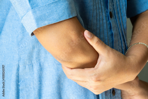 Canvas Print woman has pain in his elbow and tendon muscles and he relieves the pain with a massage